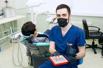 Фото стоматолога, который показывает насадки для стоматологических инструментов