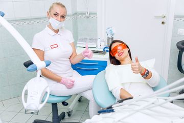 Фото стоматолога и пациента после профессиональной чистки зубной эмали